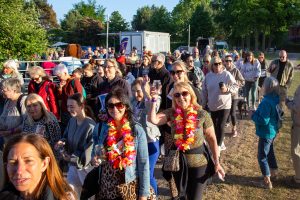 Photo of a large group of Starlight Walk participants setting off walking in the evening sun.
