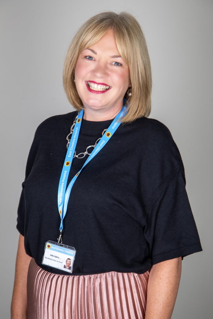 Philanthropy Assistant Sally Dykins against a grey background smiling at the camera