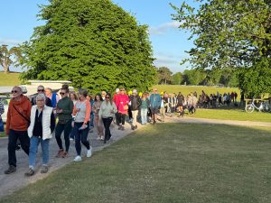 Photo of walkers in sunshine making their way round the Capesthorne circuit at Starlight Walk