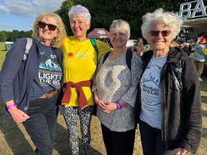 Photo of a group of four Starlight Walk participants in evening sunshine smiling at the camera