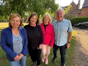 Photo of 4 Starlight Walk participants by a tree in front of Capesthorne Hall smiling at the camera.