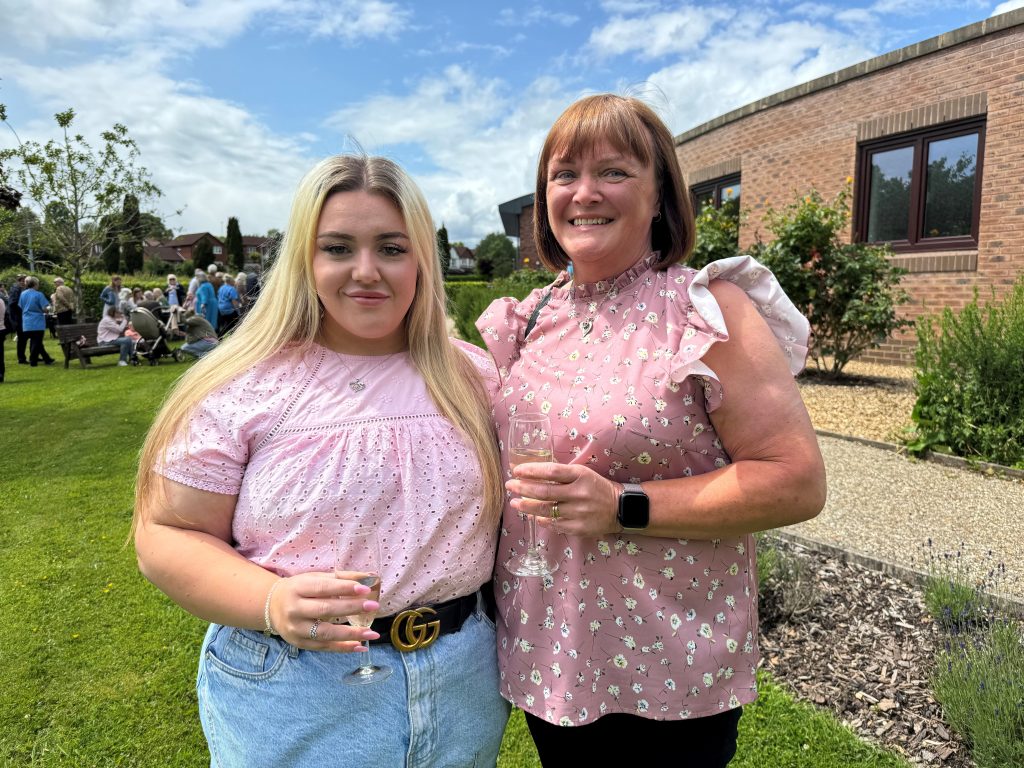 Photo of Shane's daughter Hannah and wife Sally smiling at the camera together in at the Hospice's Memory Tree Garden Party
