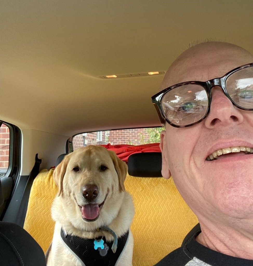 "Selfie" photo taken by Shane inside a car of himself with pet Labrador Jenson sitting on the back seat