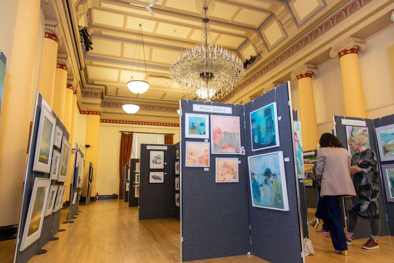 Photo of a large hall with lots of art hung on display boards