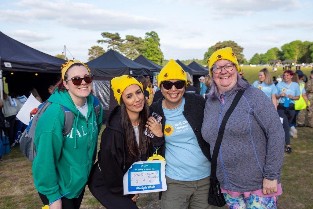 Photo of four people at Starlight Walk 2025 smiling at the camera in the event village