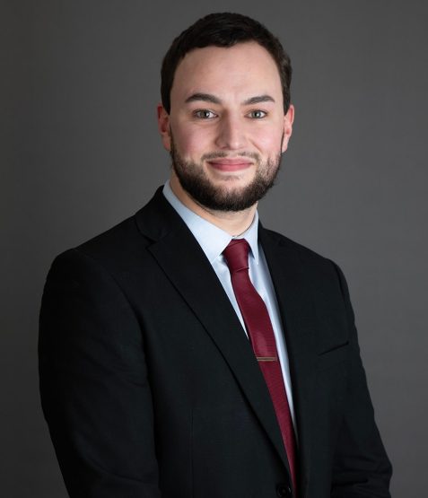 Portrait photo of Head of IT Conor Stubbs against a dark grey background