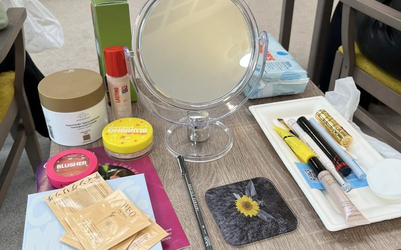 Photo of a Look Good Feel Better participant's table which has various beauty products on it from the goodie bag included in the course as well as a mirror.