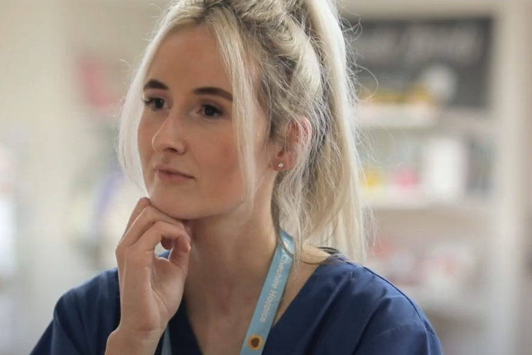 A lady who works for East Cheshire Hospice is looking away from the camera